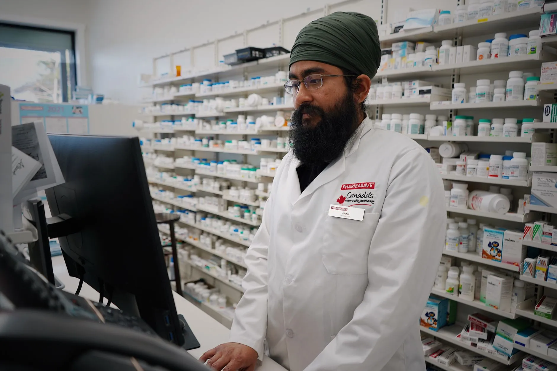 A pharmacist working at the counter of a pharmacy.
