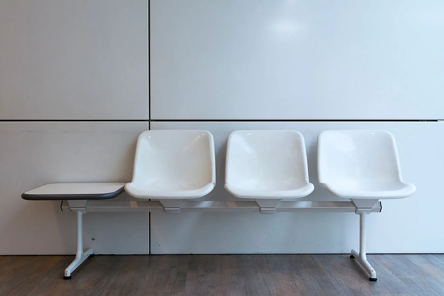 Empty chairs lined up along a clinic corridor.