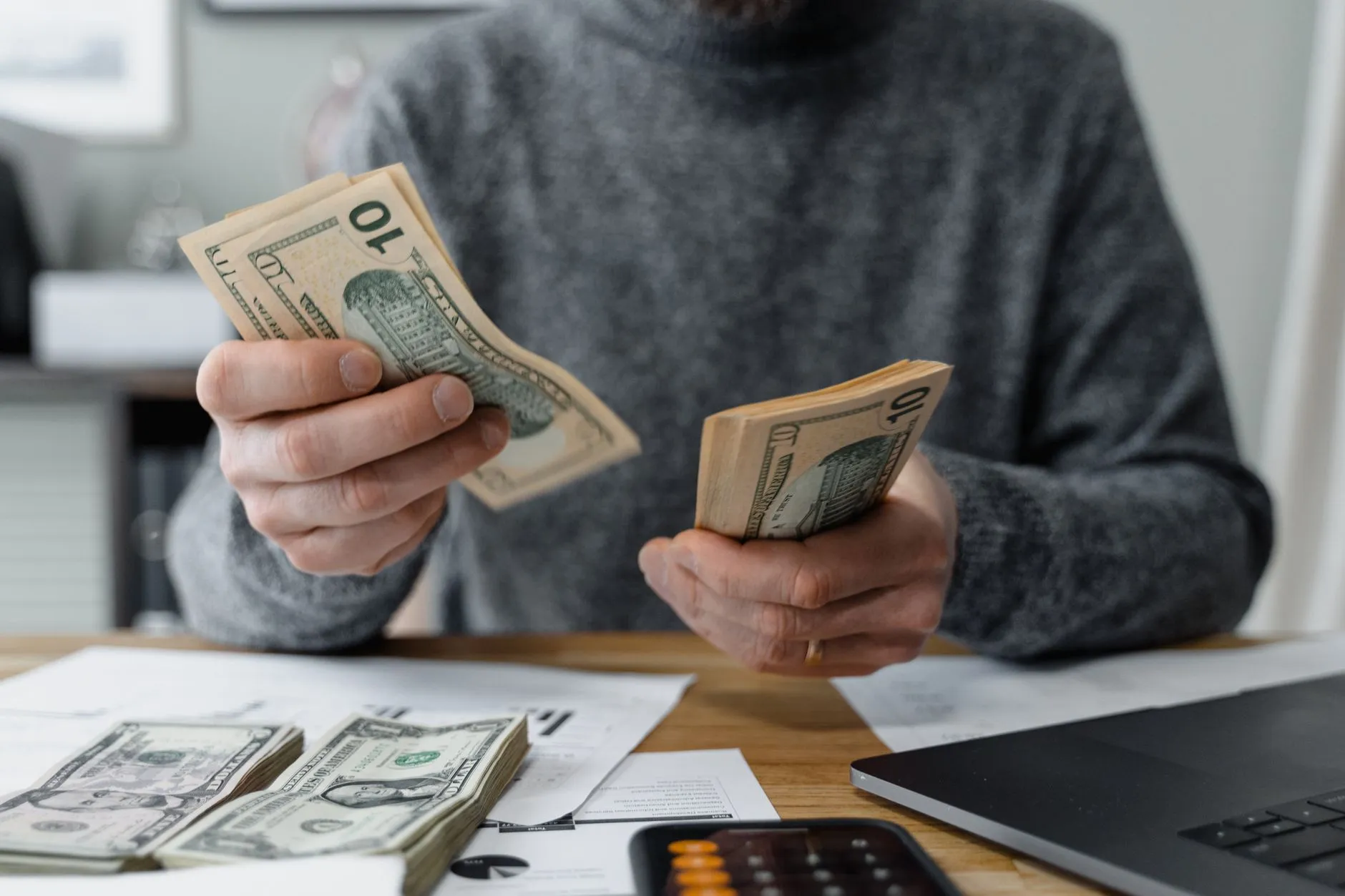 A person counting cash at a desk.