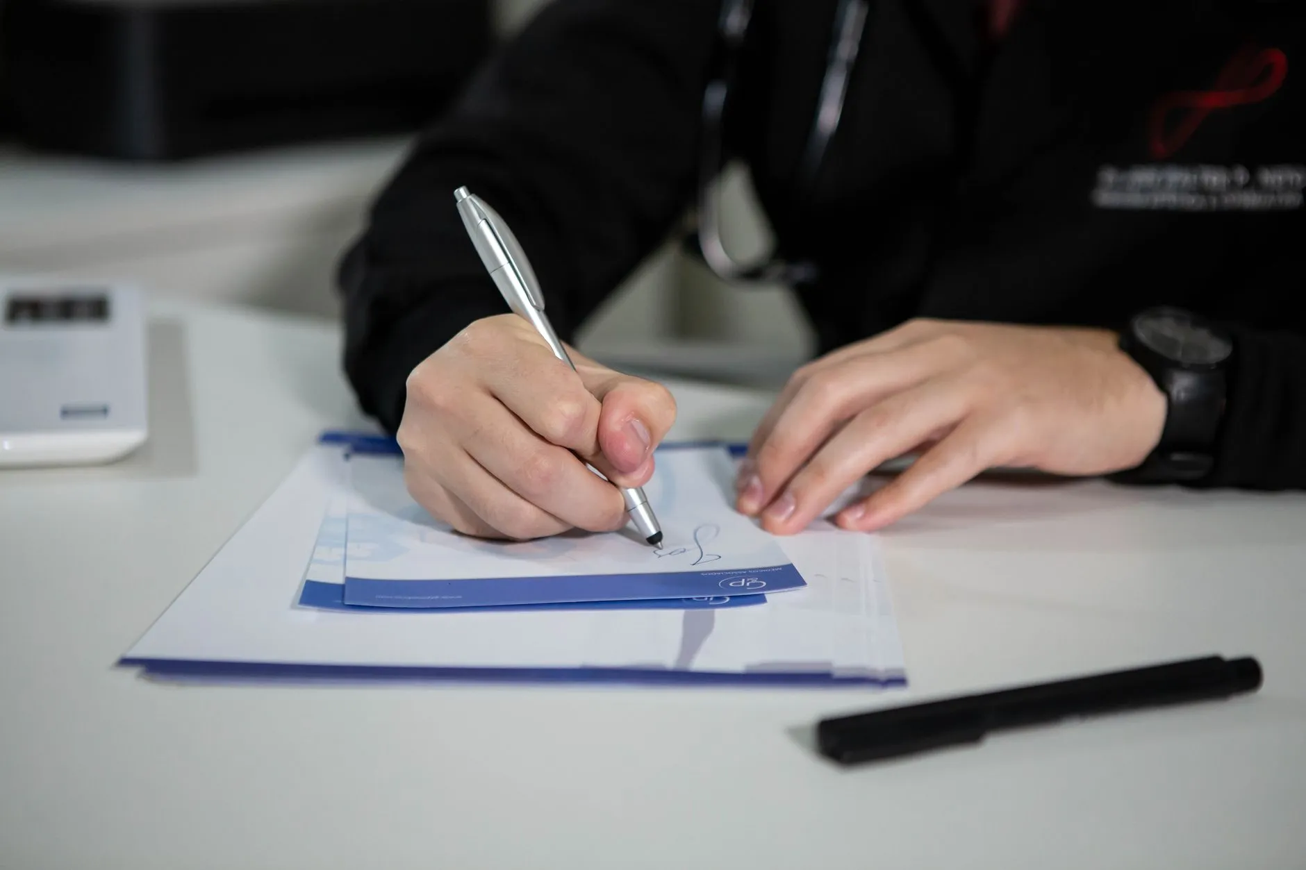A doctor writing a prescription with a pen.