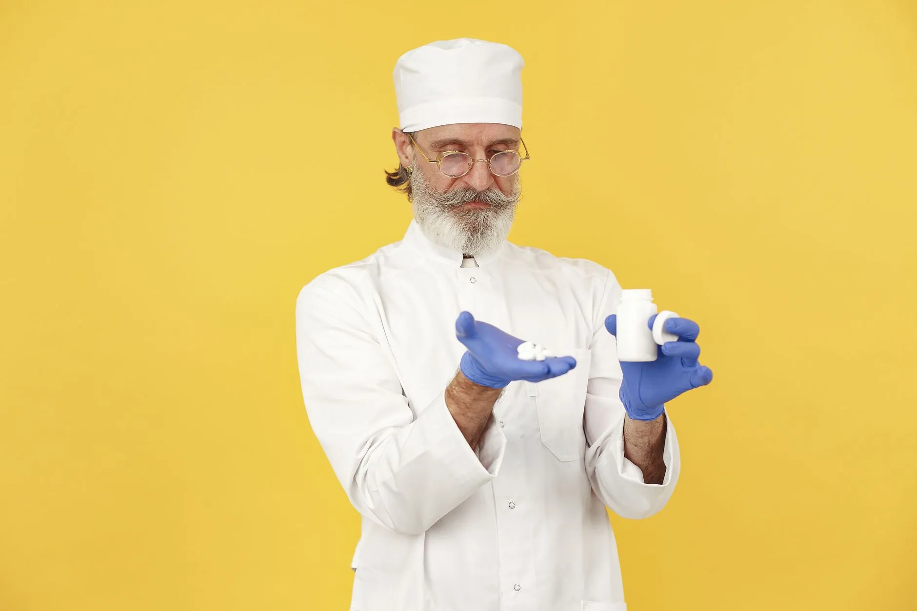 A pharmacist examining medicines in their palm.